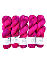 Five skeins of pink yarn with 'Baah Yarn La Jolla' labels on a white background to display the hand dyed color differences in shades and tones